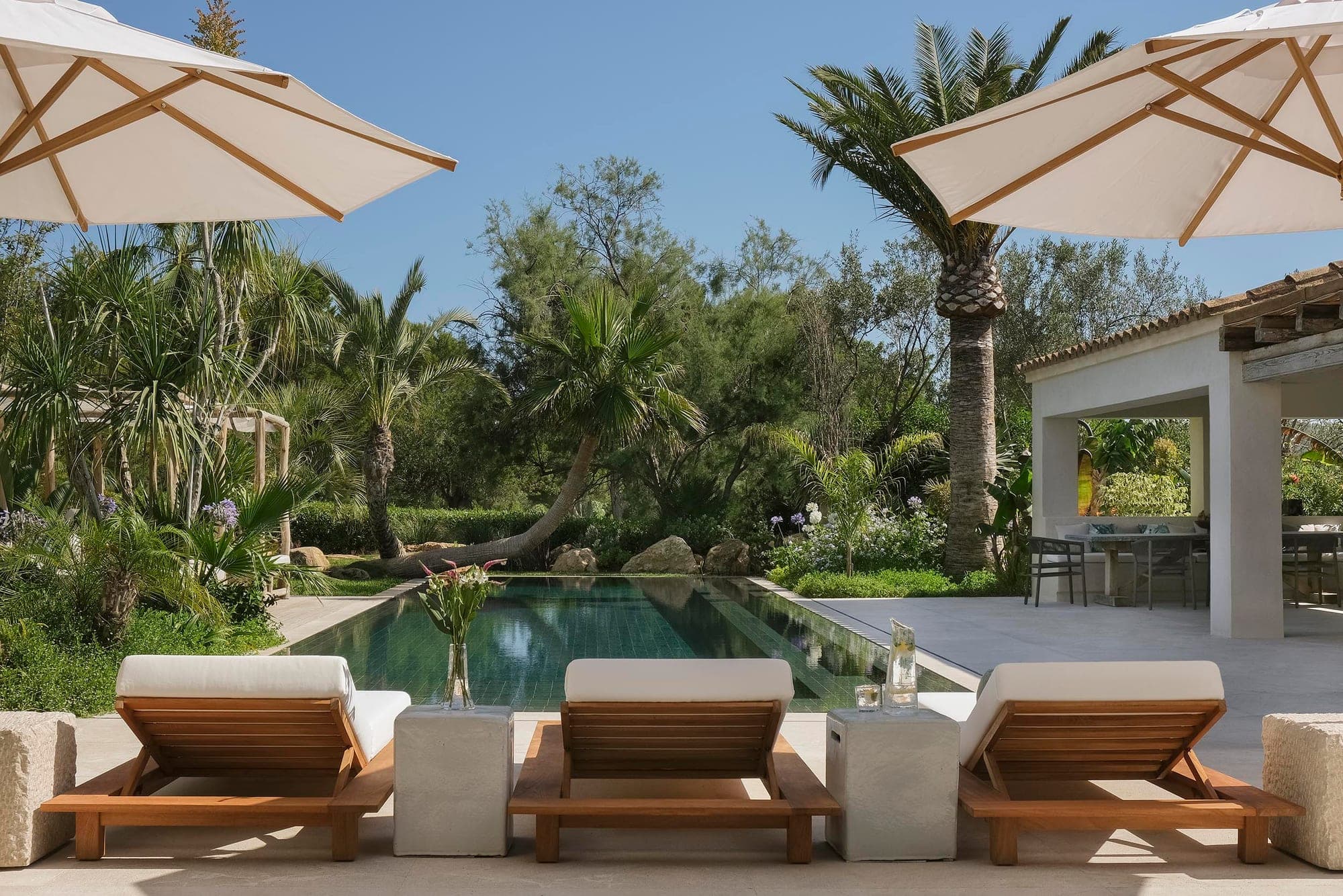 Outdoor terras met Sempre-loungezetels en parasols rond een zwembad